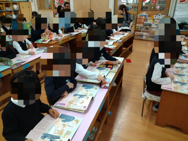 教科書（絵本）を見てお話を聞いています