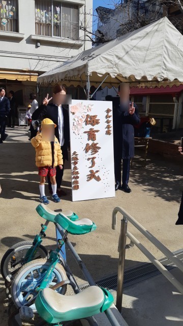 修了式の看板の前で